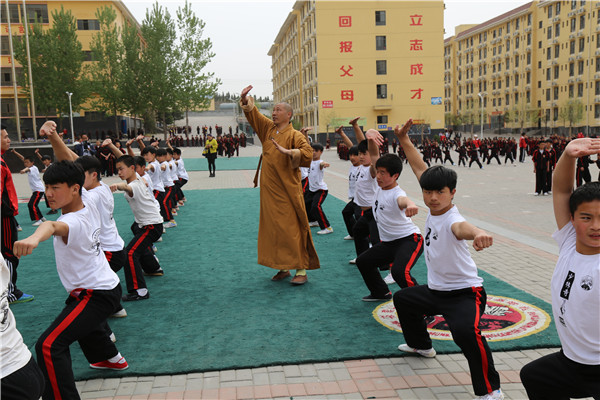 嵩山少林文武学校学生在少林寺武僧总教头释延鲁大师的指导下学习少林功夫